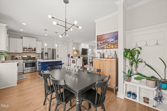 dining room with a chandelier, recessed lighting, crown molding, and light wood-style flooring