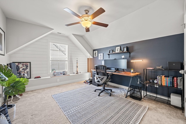 office space featuring light colored carpet, visible vents, a ceiling fan, vaulted ceiling, and baseboards