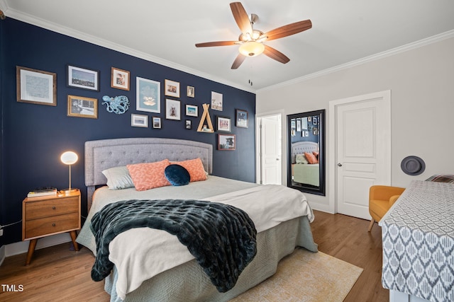 bedroom featuring ornamental molding, wood finished floors, a ceiling fan, and baseboards