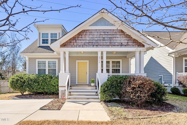 view of front of home with covered porch and a shingled roof