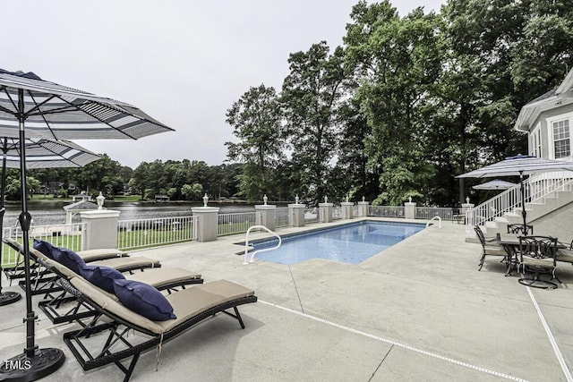 view of pool featuring a patio and a water view