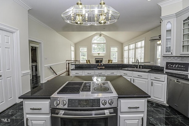 kitchen with white cabinetry, stainless steel appliances, sink, and a kitchen island