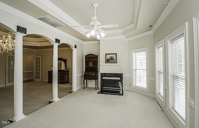 living room featuring crown molding, a premium fireplace, decorative columns, carpet, and a tray ceiling