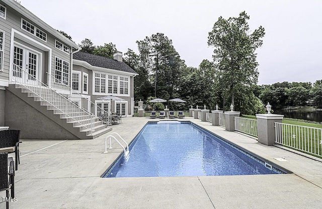 view of swimming pool with french doors and a patio