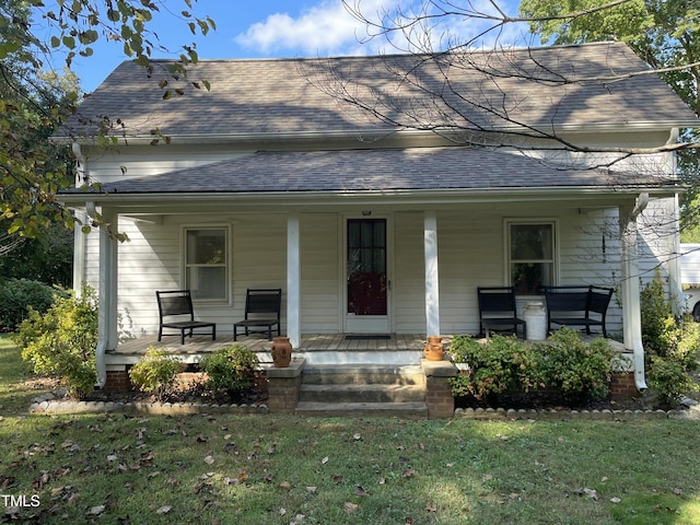 view of front of house with a front yard and covered porch