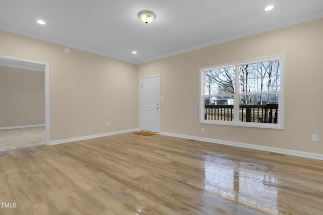 empty room featuring ornamental molding and light hardwood / wood-style floors