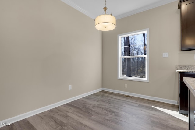 unfurnished dining area with ornamental molding and light hardwood / wood-style flooring