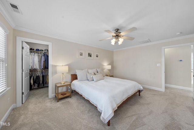 bedroom with light carpet, visible vents, a walk in closet, crown molding, and a closet