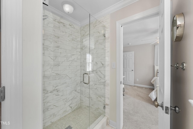 bathroom with a ceiling fan, crown molding, a shower stall, and baseboards