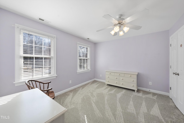 interior space featuring baseboards, visible vents, and ceiling fan