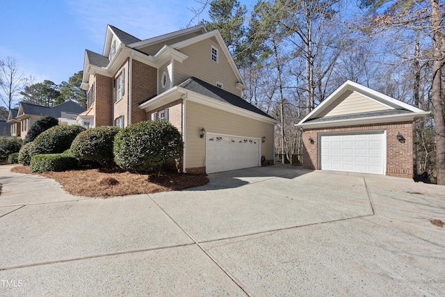 view of side of property with a detached garage and brick siding