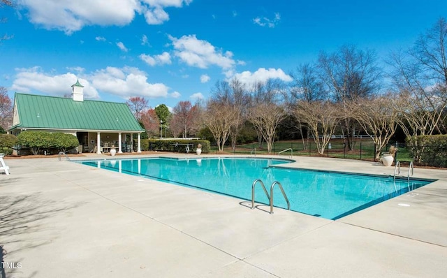 community pool featuring a patio and fence