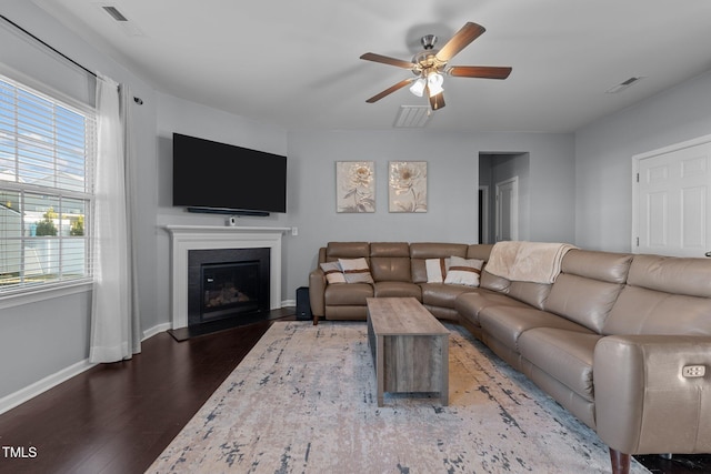 living room featuring dark wood-type flooring and ceiling fan