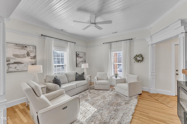 living room with crown molding, ceiling fan, decorative columns, and light wood-type flooring