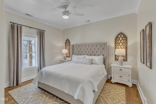 bedroom with ornamental molding, ceiling fan, and light hardwood / wood-style floors