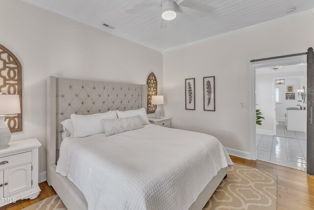 bedroom featuring crown molding, ceiling fan, and light hardwood / wood-style floors