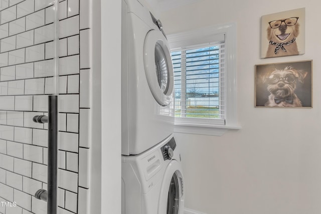 clothes washing area with a healthy amount of sunlight and stacked washing maching and dryer