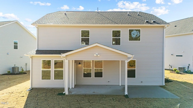 rear view of property featuring a patio, a yard, and central AC unit