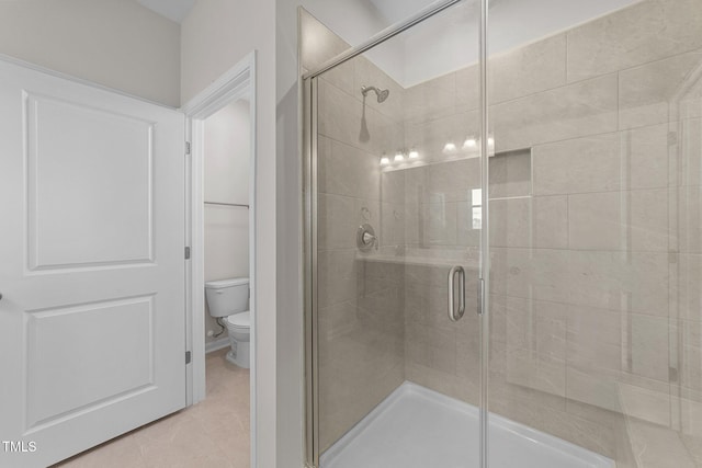 bathroom featuring walk in shower, toilet, and tile patterned flooring