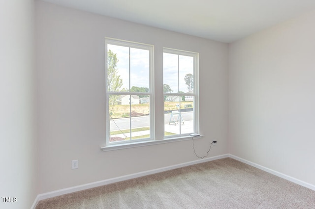 unfurnished room featuring light carpet