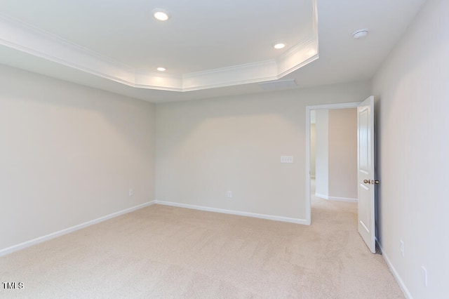 carpeted empty room with ornamental molding and a tray ceiling