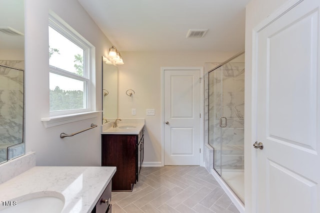 bathroom with vanity, plenty of natural light, and a shower with door