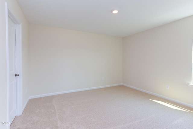 spare room featuring light colored carpet