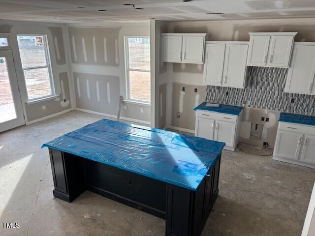 kitchen featuring a kitchen island, plenty of natural light, and white cabinets