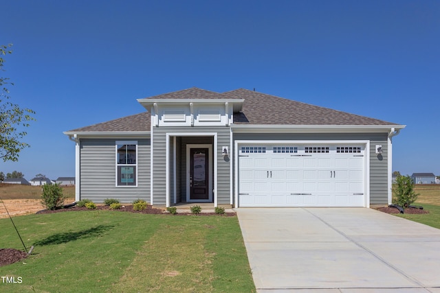 view of front of house featuring a garage and a front lawn