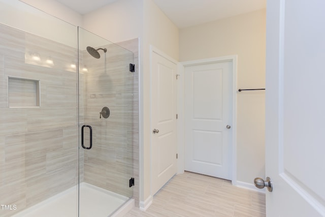 bathroom with a shower with door