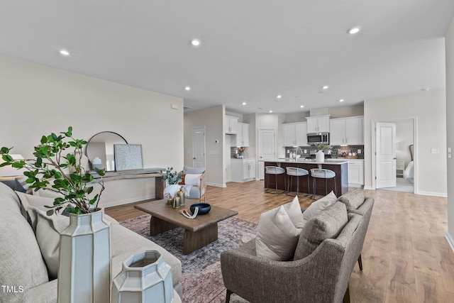 living room with sink and light hardwood / wood-style flooring