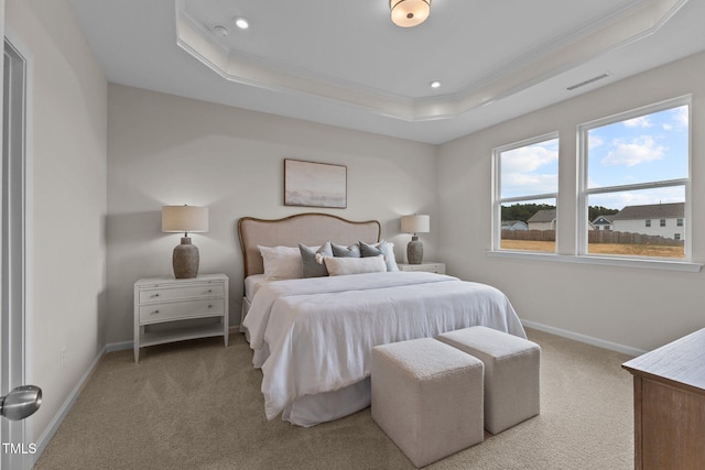 carpeted bedroom featuring a raised ceiling and crown molding