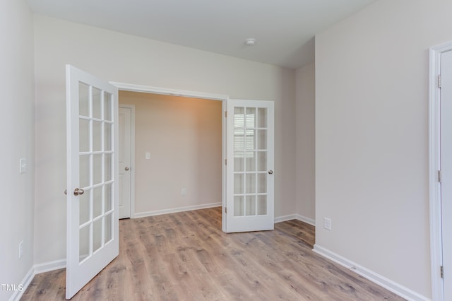 spare room with light hardwood / wood-style flooring and french doors