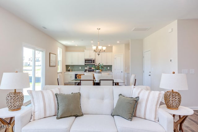 living room with an inviting chandelier and light wood-type flooring