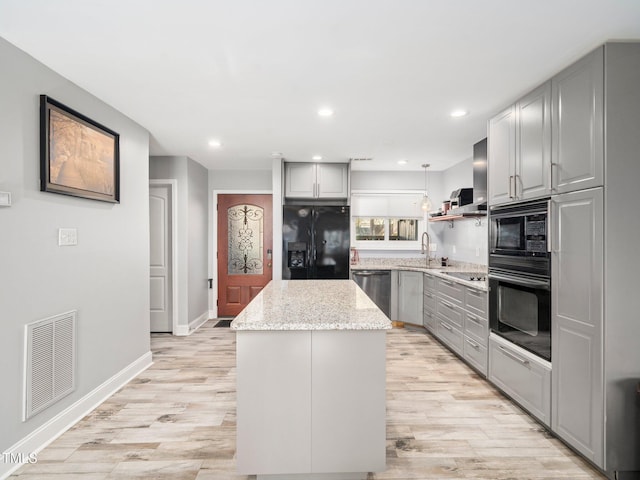 kitchen with a kitchen island, pendant lighting, gray cabinetry, and black appliances