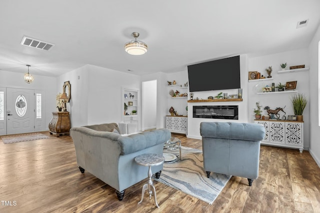 living room featuring wood-type flooring and a chandelier