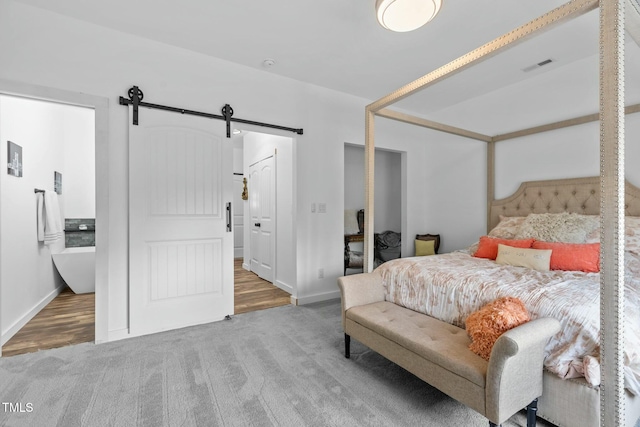 bedroom featuring a barn door and carpet