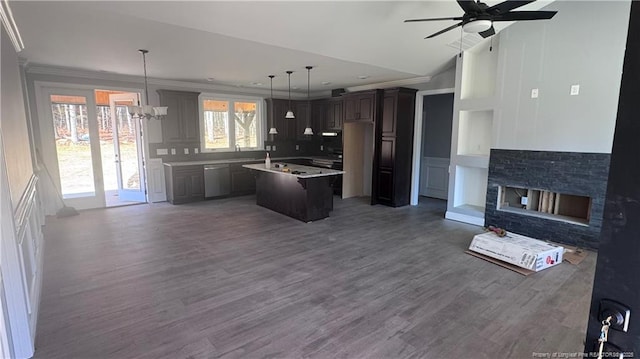 kitchen featuring dark brown cabinetry, a center island, hanging light fixtures, dishwasher, and a fireplace