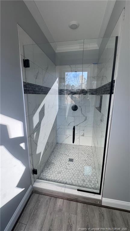 bathroom with an enclosed shower and crown molding