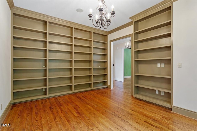 spacious closet with a chandelier and wood finished floors