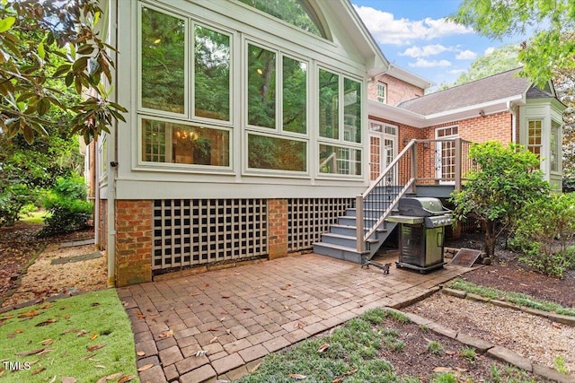 rear view of house with a patio, brick siding, and an attached garage
