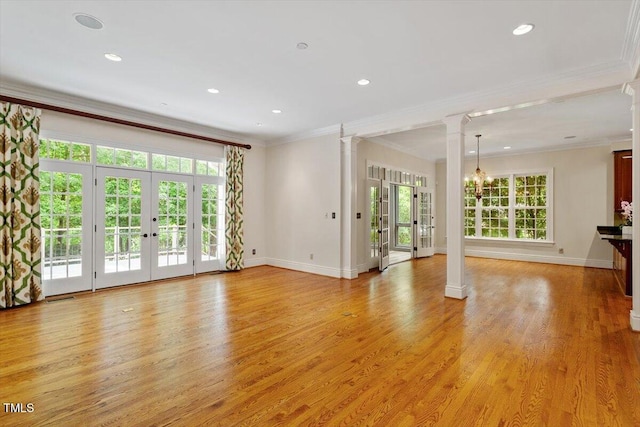 unfurnished living room with french doors, decorative columns, ornamental molding, baseboards, and light wood-style floors