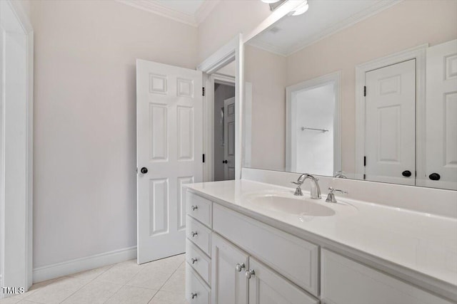 bathroom with tile patterned floors, ornamental molding, baseboards, and vanity