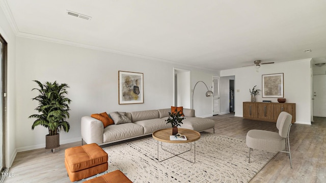 living room featuring ornamental molding, light hardwood / wood-style floors, and ceiling fan