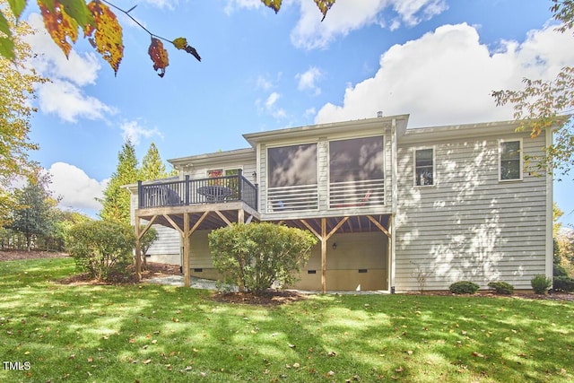 back of house with a deck and a lawn