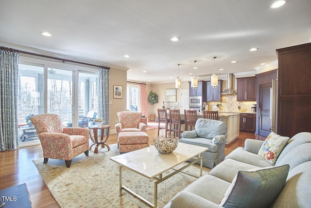 living room featuring crown molding and light hardwood / wood-style floors