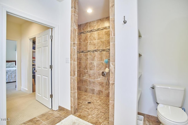 bathroom with tiled shower and toilet