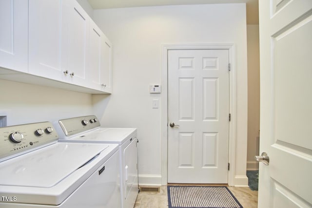 clothes washing area featuring cabinets and independent washer and dryer