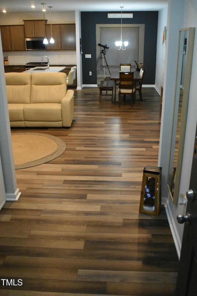 living room with an inviting chandelier and dark hardwood / wood-style flooring