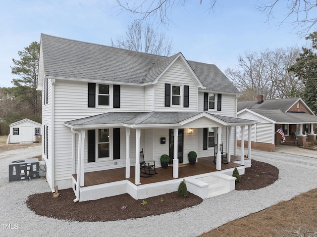 view of front of property with a porch, a storage shed, and central air condition unit